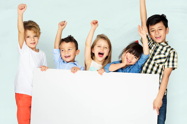 Free Photo | Little kids cheering while holding a white board