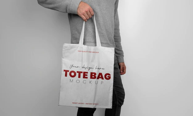 Free PSD | Mockup of model holding a white tote bag