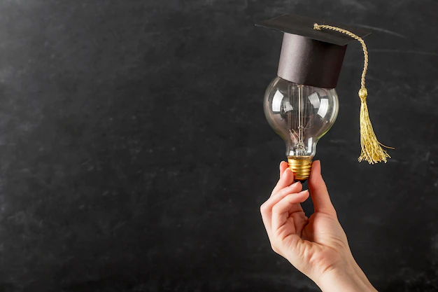Free Photo | Person holding a light bulb with graduation cap