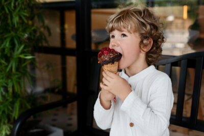 Free Photo | Side view boy licking ice cream cone