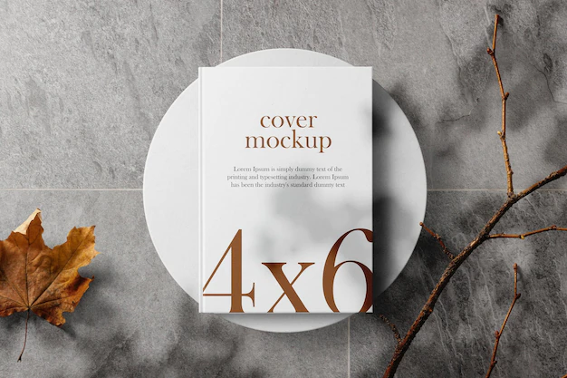 Free PSD | Clean minimal book 4x6 mockup on white plate with stick and marple leaf