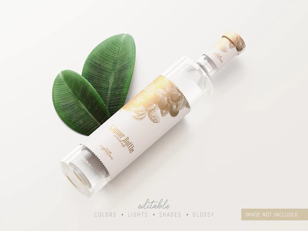 Free PSD | Clear glass liquor bottle mockup decorated with green leaves