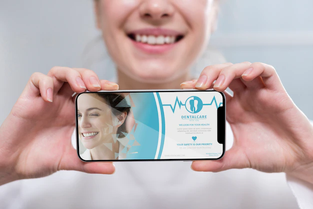 Free PSD | Close-up dentist holding a smartphone mock-up