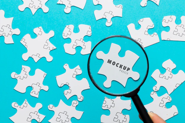 Free PSD | Close-up man with magnifying glass and pieces of puzzle