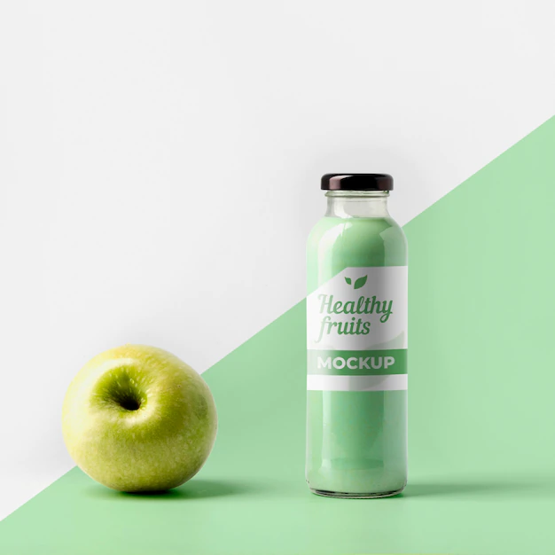 Free PSD | Front view of transparent juice bottle with cap and apple