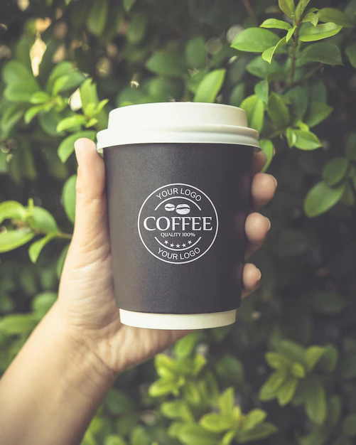 Free PSD | Hand holding a coffee paper cup mockup