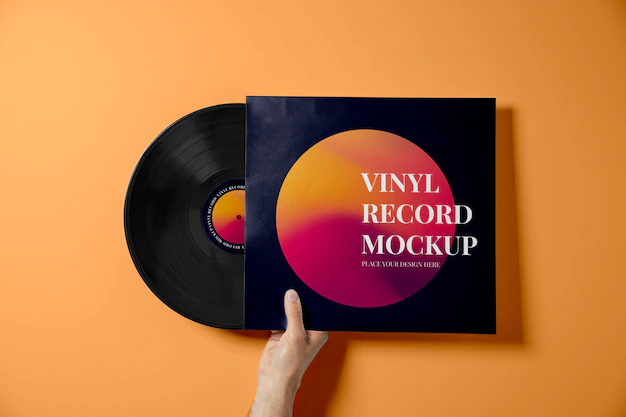 Free PSD | Hand holding vinyl record with orange background