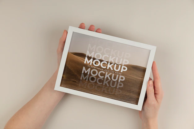 Free PSD | Hands holding white frame mockup flat lay