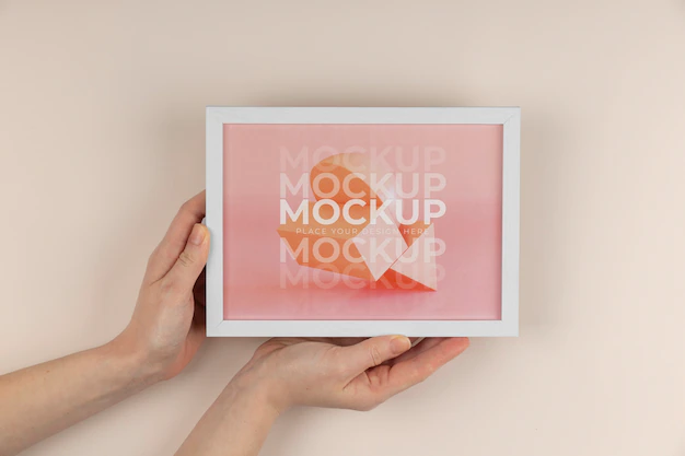 Free PSD | Hands holding white frame mockup top view