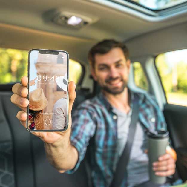 Free PSD | Man in car showing smartphone mockup