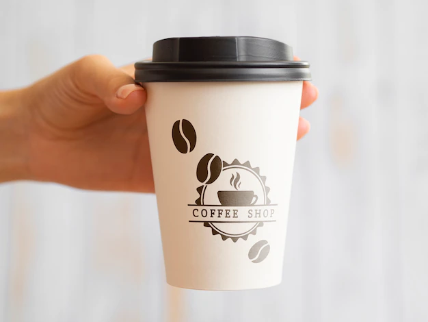 Free PSD | Person holding up a coffee paper cup