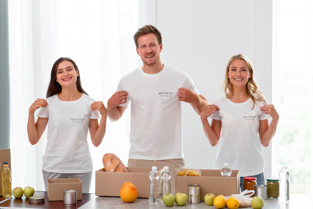 Free PSD | Smiley volunteers holding their t-shirts while preparing food for donation