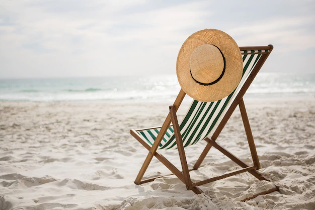 Free Photo | Straw hat kept on empty beach chair