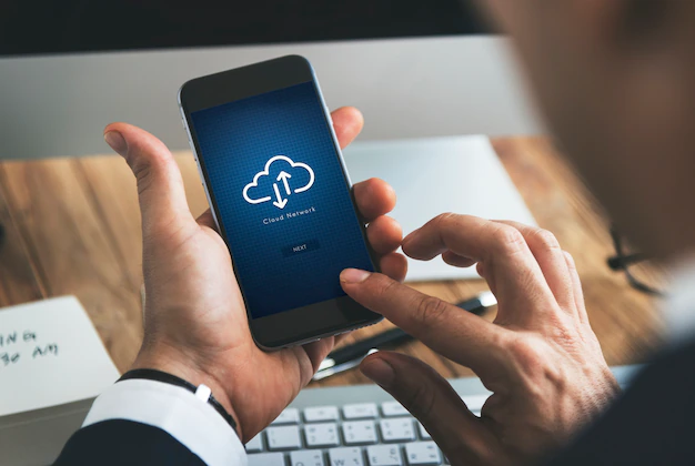 Free PSD | Closeup of businessman using smartphone with cloud computing symbol