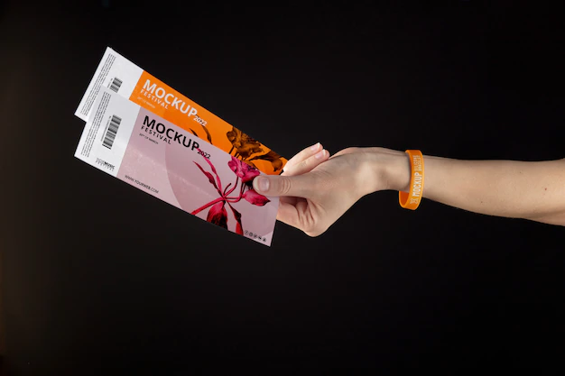 Free PSD | Hand with music fest bracelet holding mock-up tickets