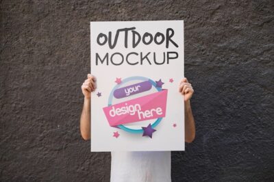 Free PSD | Man presenting poster mockup in front of wall