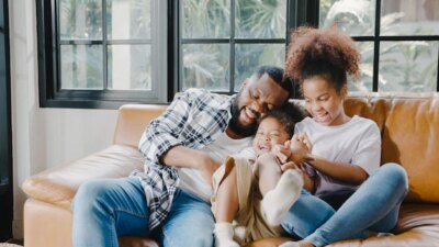Free Photo | Happy cheerful african american family dad and daughter having fun cuddle play on sofa while birthday at house.
