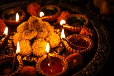 Free Photo | Happy diwali - flower rangoli with sweets or mithai and diya in bowls for diwali or any other festivals in india, selective focus