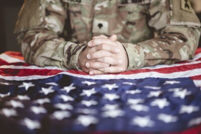 Free Photo | American soldier mourning and praying with the american flag in front of him