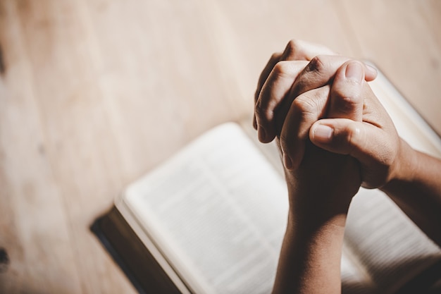 Free Photo | Spirituality and religion, hands folded in prayer on a holy bible in church concept for faith.