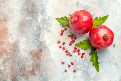 Free Photo | Top view red pomegranates pomegranate seeds on nude surface with copy space
