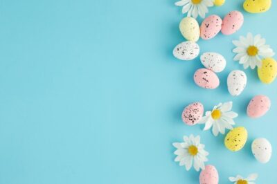 Free Photo | Easter invitation with eggs and daisies on a blue background with copy space