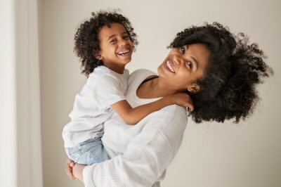 Free Photo | Smiley mother holding kid side view